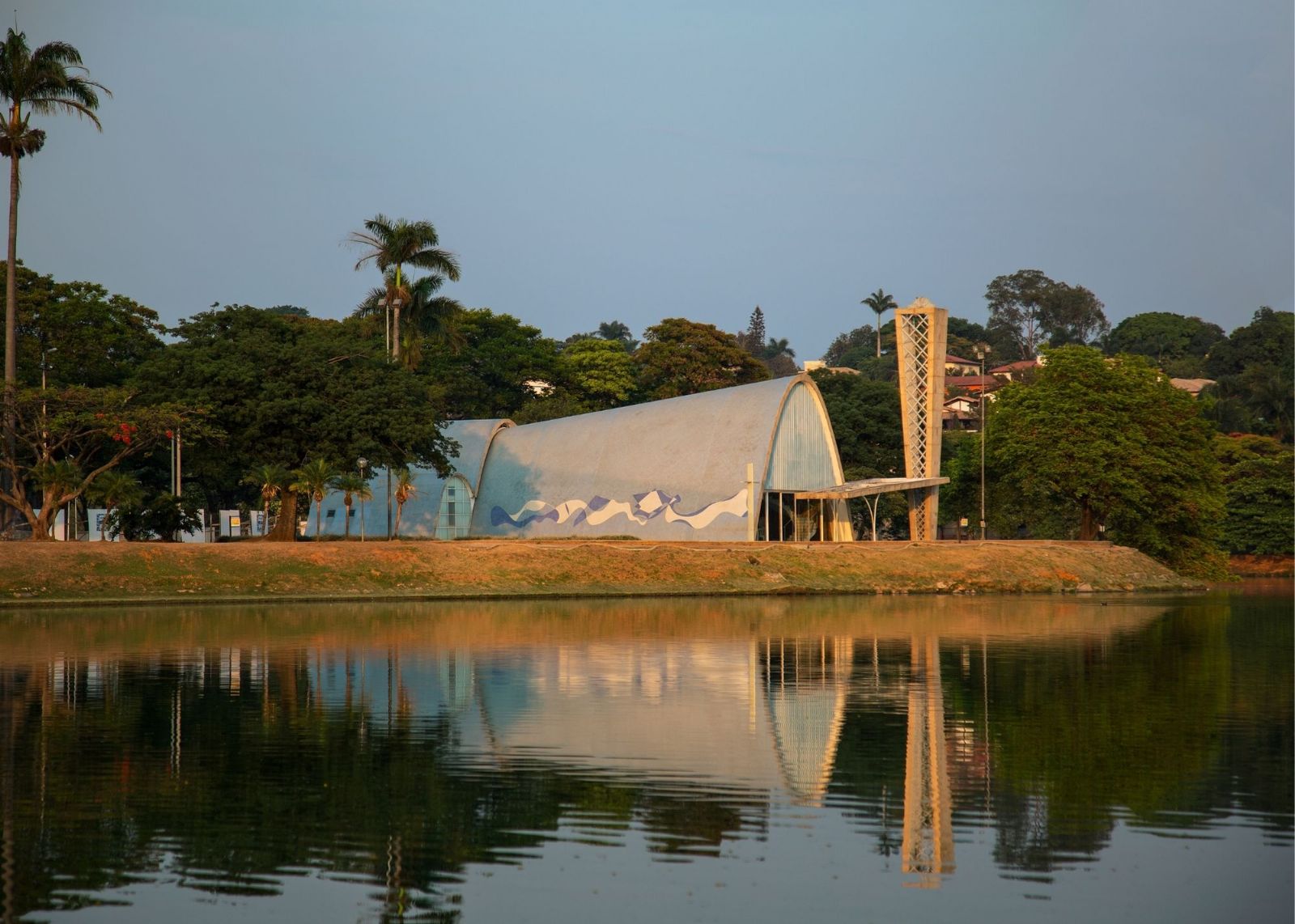 museu no meio de árvores e atrás de lago