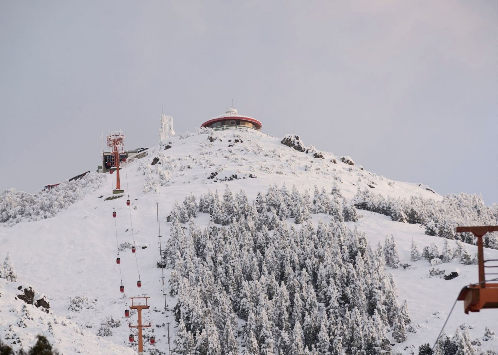 montanha com muita neve e teleférico