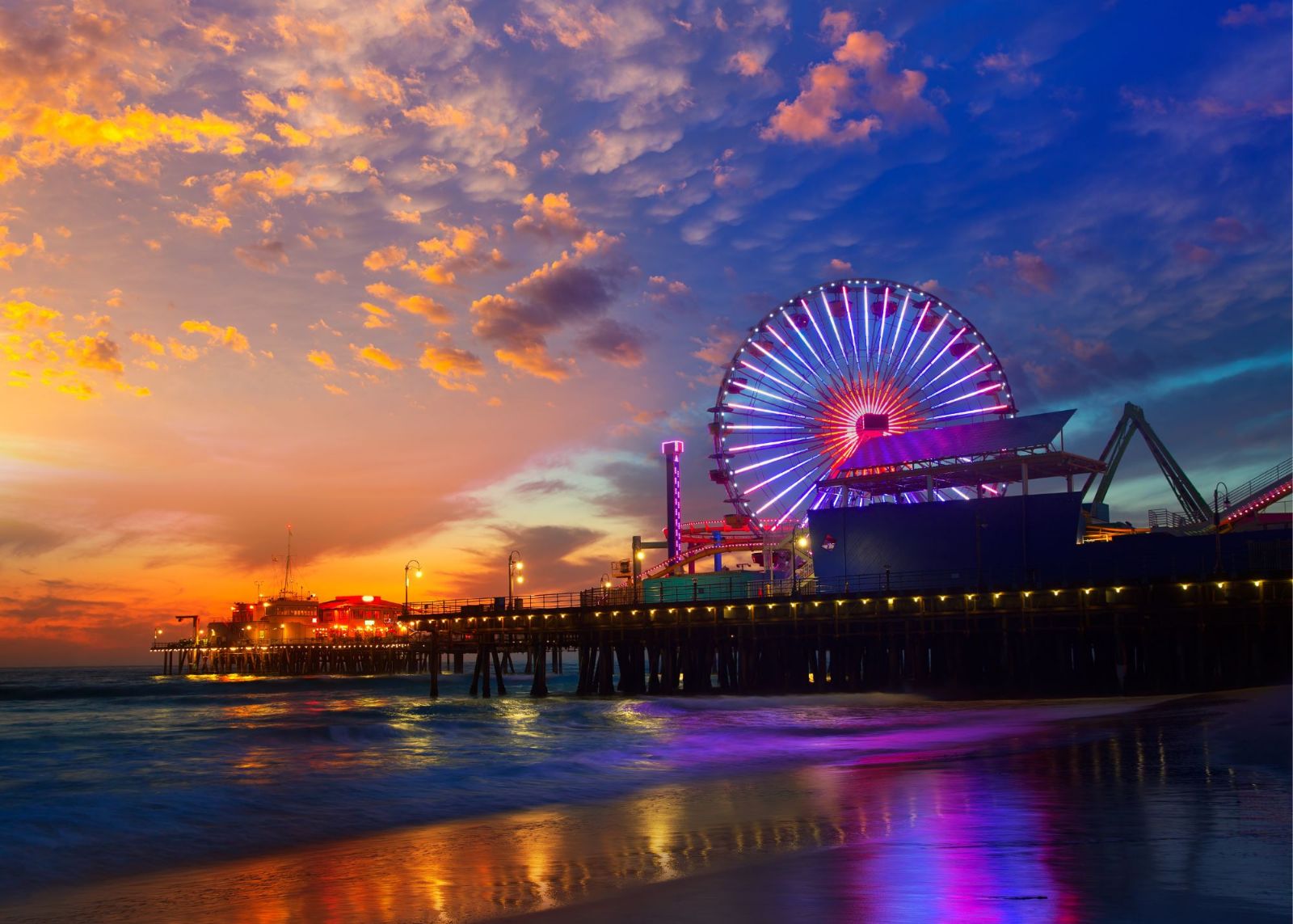 pôr do sol em pier com mar e roda gigante