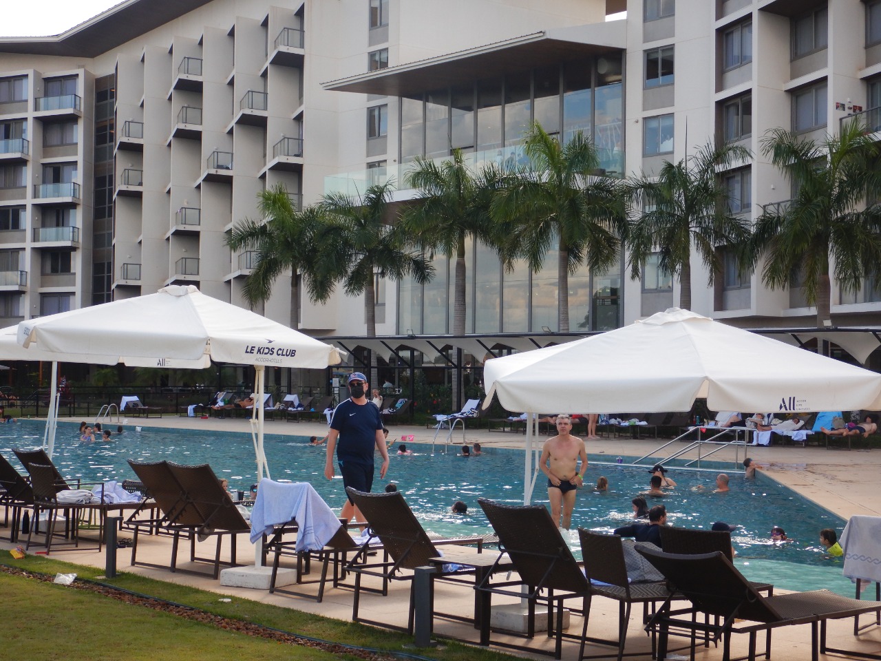 area de piscina com predio do hotel ao fundo