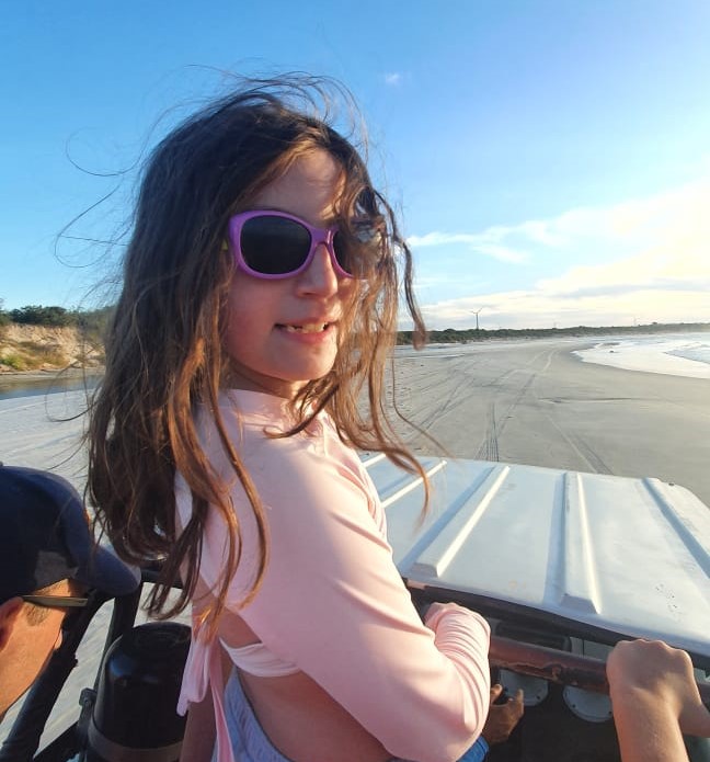 menina em pé em cima de bugue na praia