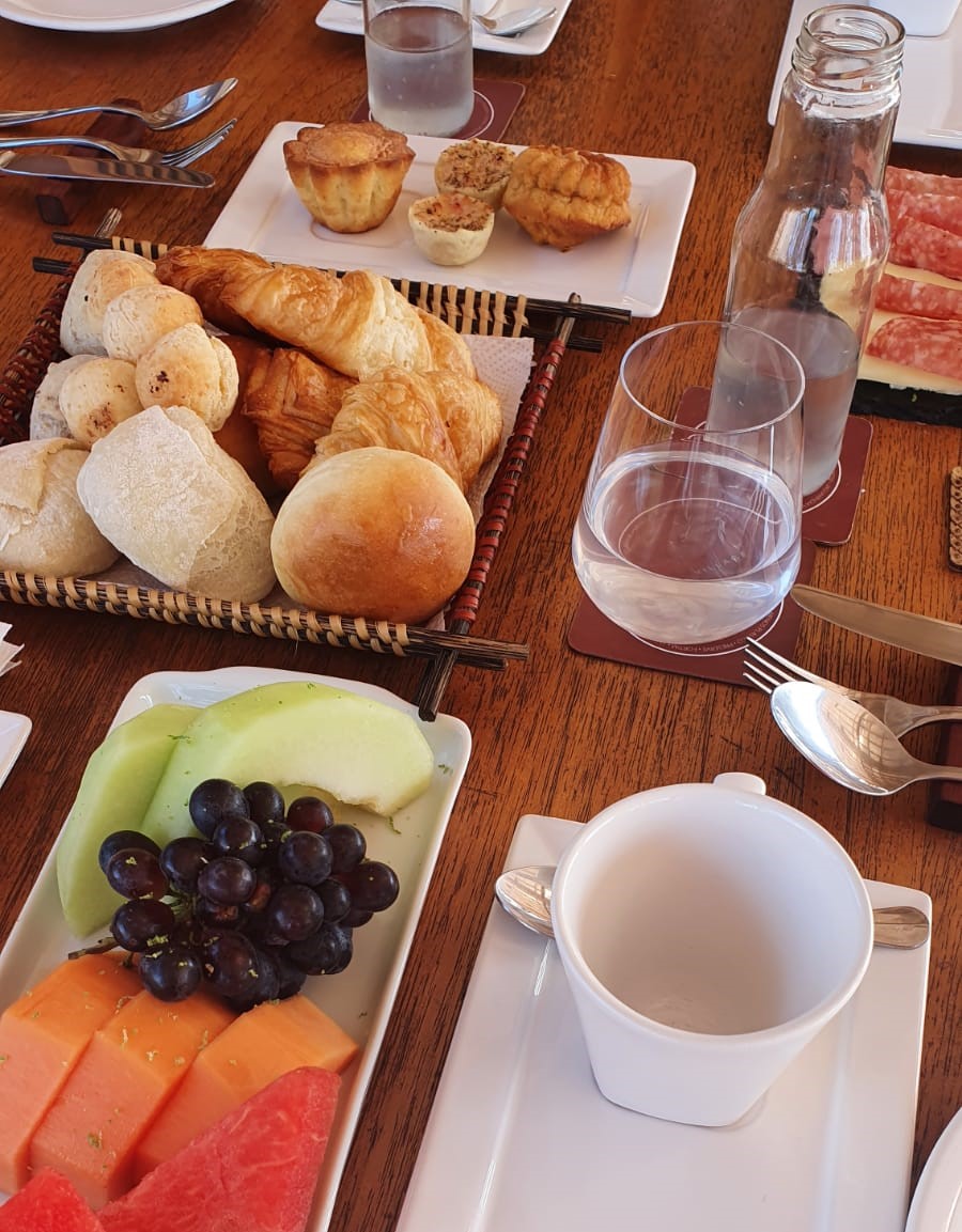 mesa posta com pratos e frutas de café da manhã