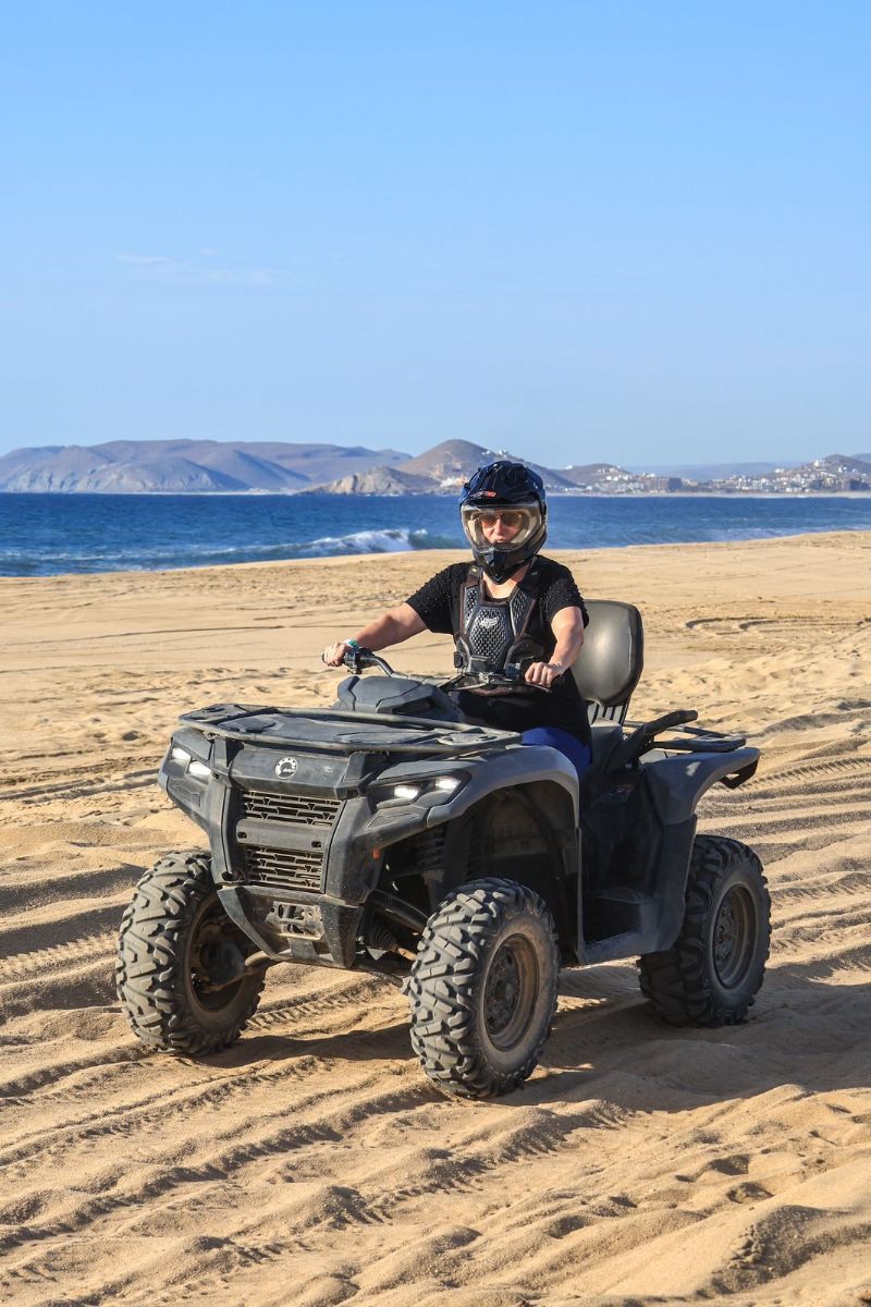 mulher pilotando quadriciclo na praia